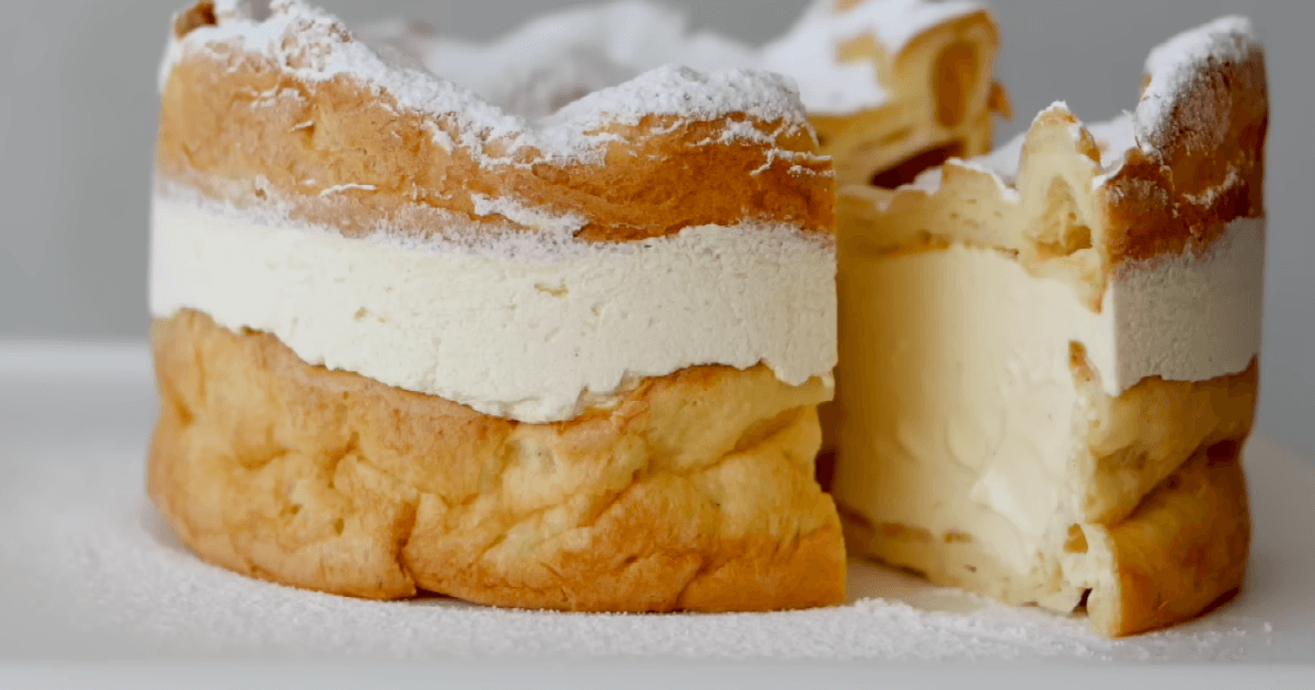 A delicious cream puff cake with golden pastry layers and creamy filling, dusted with powdered sugar.