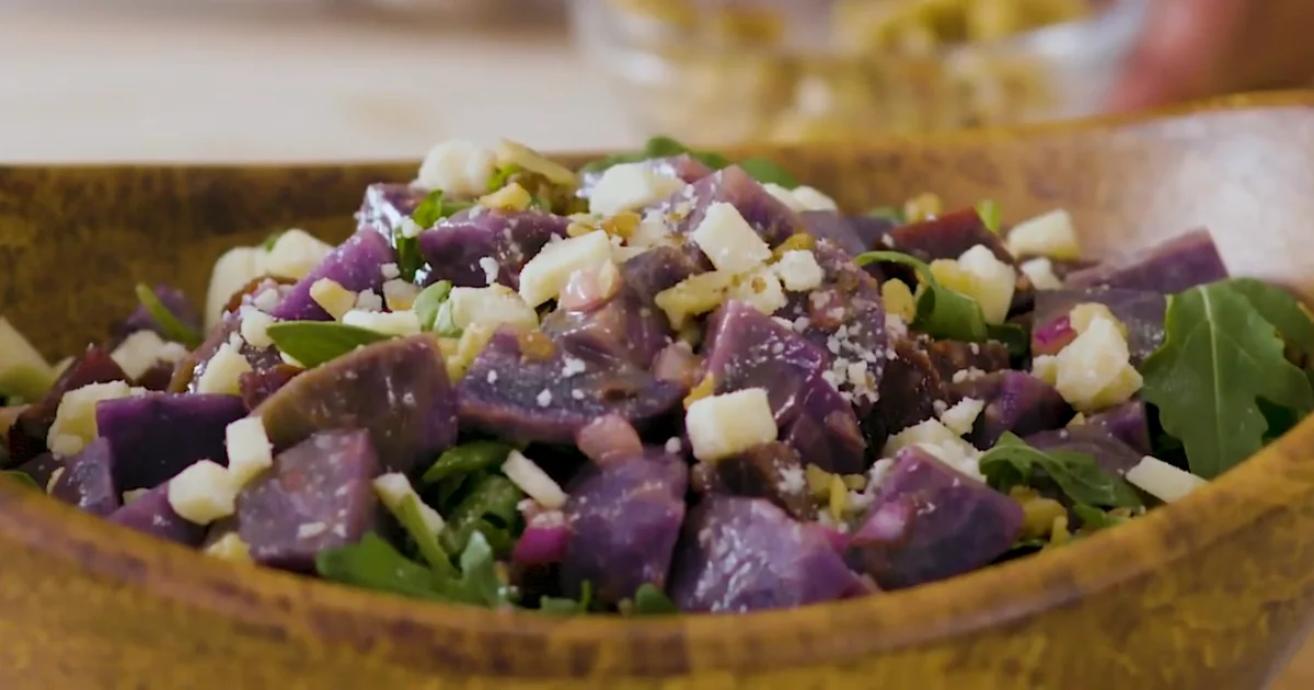 Purple potatoes on a rustic wooden table, showcasing their vibrant color and texture