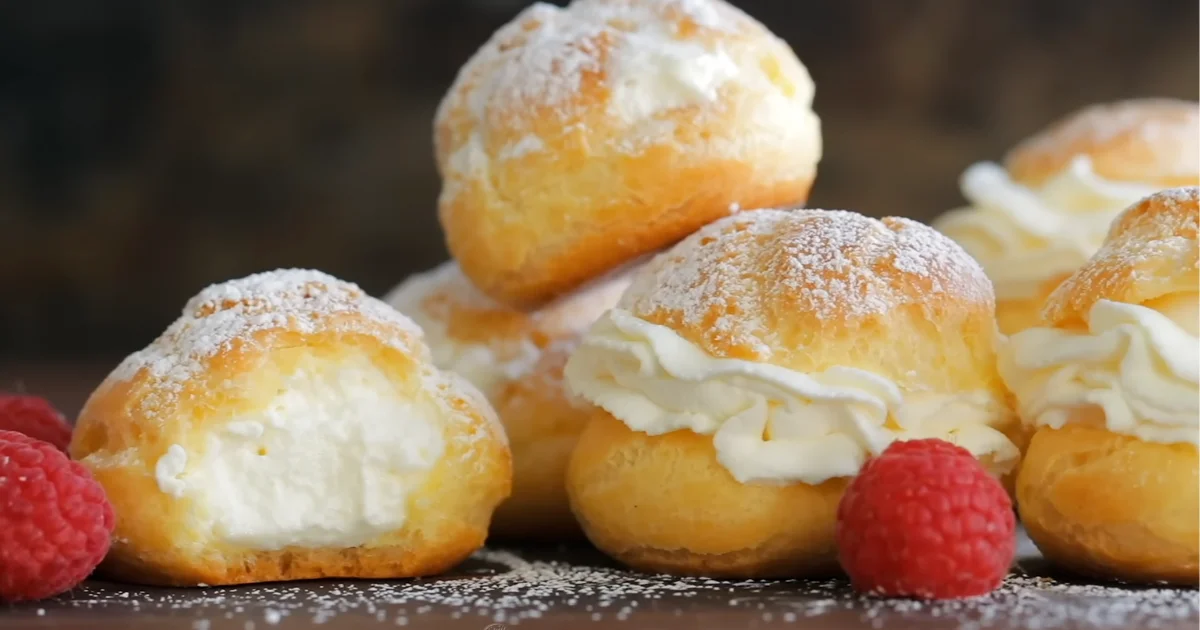 Freshly baked cream puffs with a light golden crust and creamy filling, displayed in a local bakery near me.