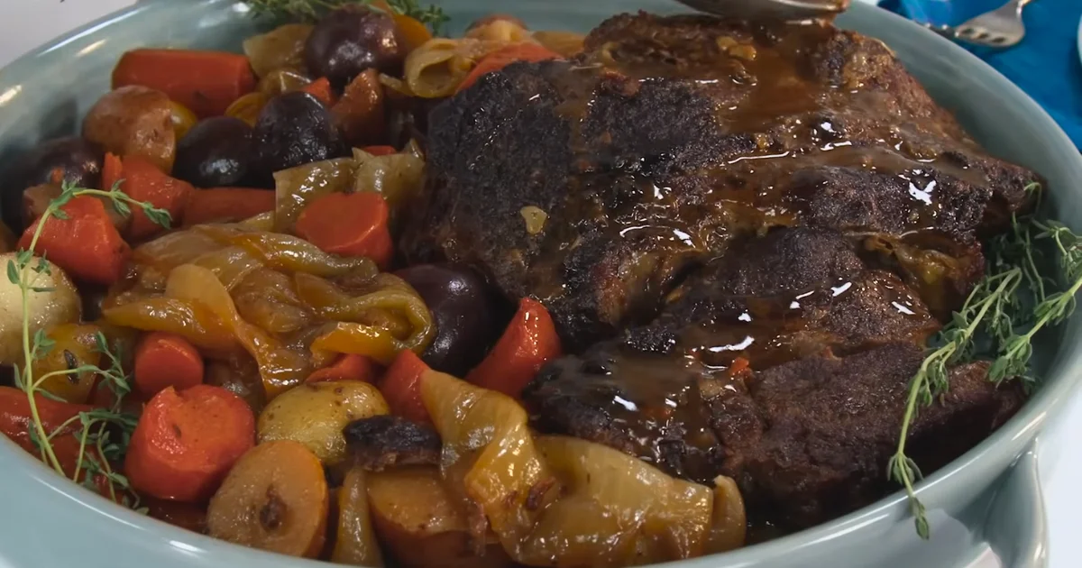 Delicious pot roast with vegetables, served on a plate with rich gravy.