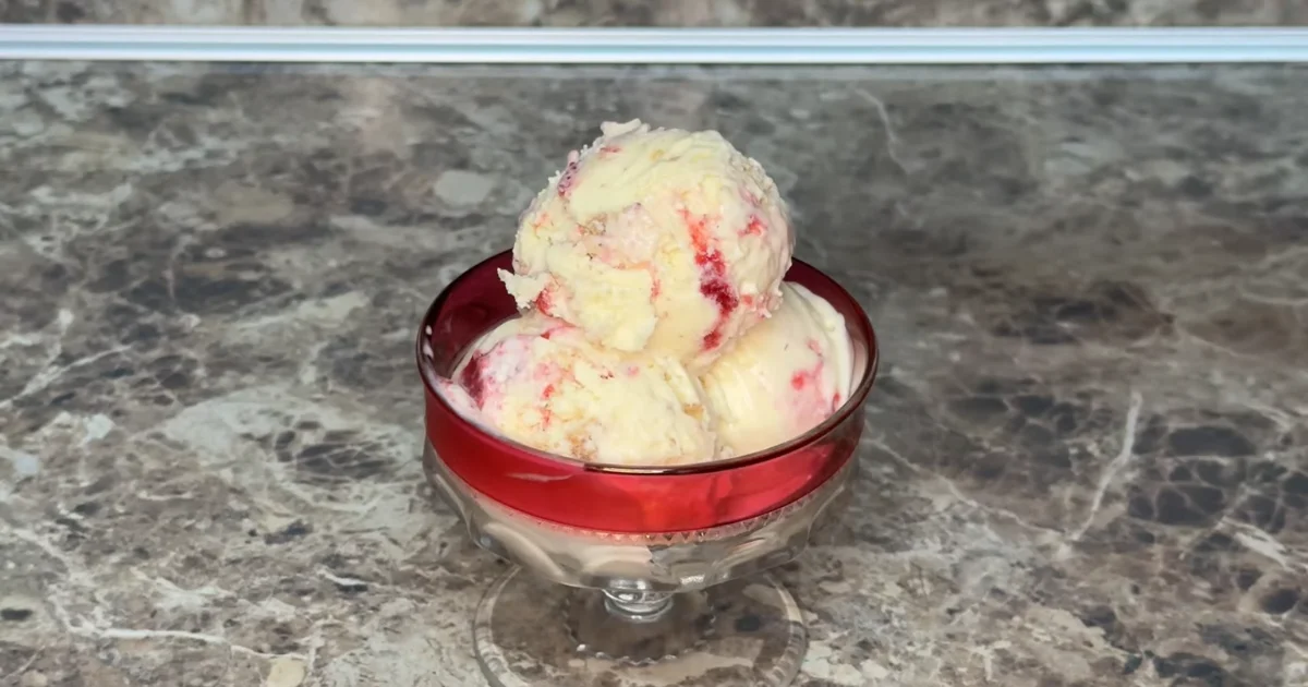 Creamy Strawberry Cheesecake Ice Cream with a graham cracker crust and fresh strawberries.