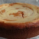 Delicious slice of Sweet Potato Cheesecake topped with whipped cream and cinnamon.